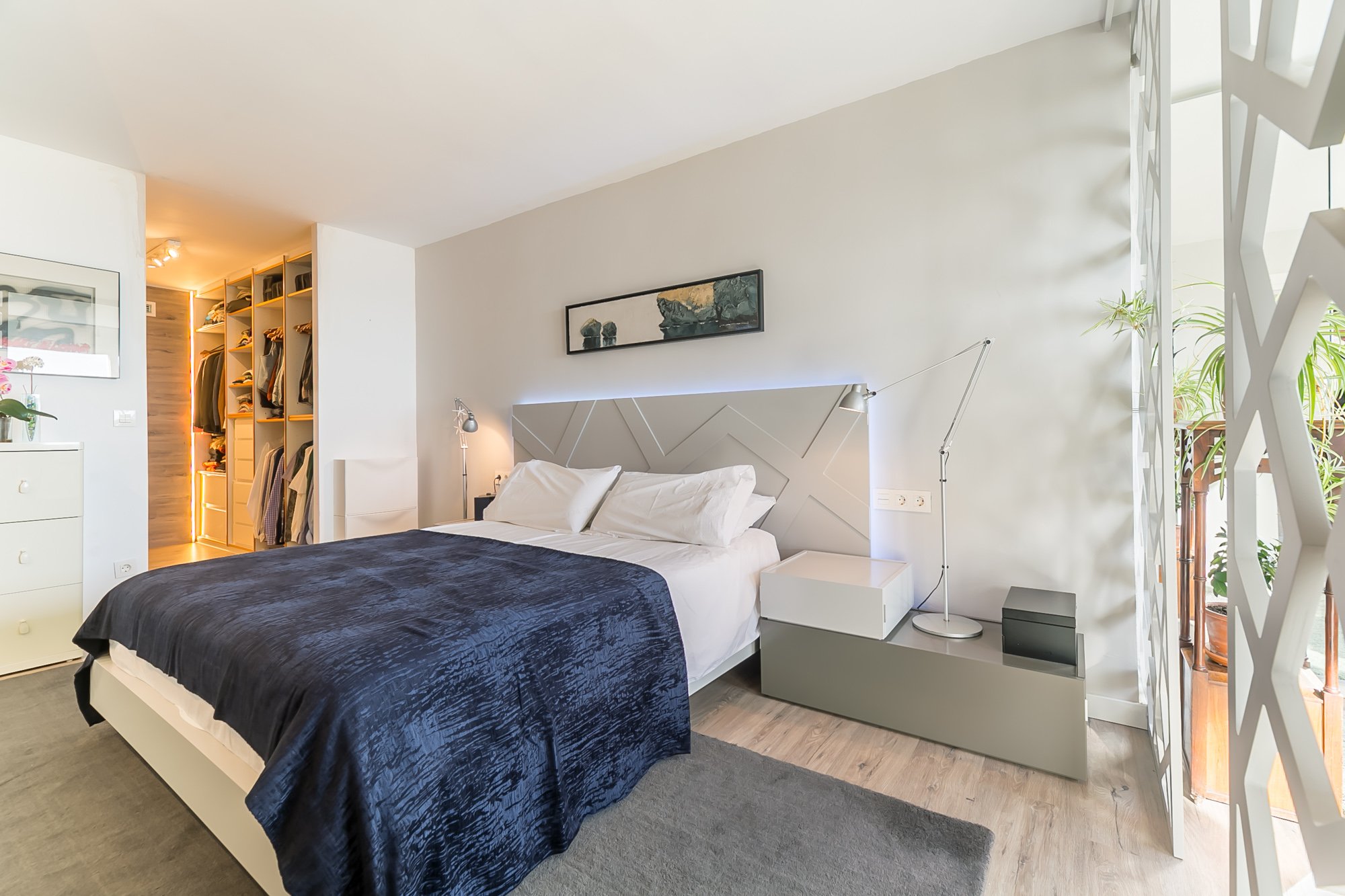 Habitación moderna con mueble gris y toques azules. ILuminación led en cabeceros.
